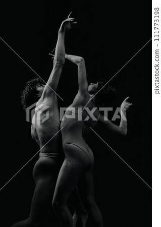 Passion, inspiration and feelings. Talented, artistic young man and woman, ballet dancers making performance, dancing. Monochrome 111773198