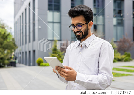 Confident entrepreneur engaging with technology in an urban setting, reflecting a blend of professionalism and accessibility. 111773737