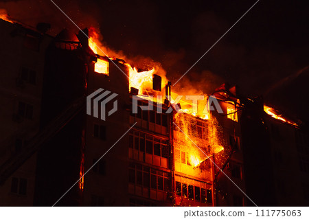 Pieces of the house fall due to the fire. Fire blazing in apartment house. 111775063