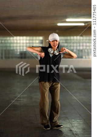 Smiling young female dancing in parking garage. Hobby and active lifestyle concept Smiling young female dancing in parking garage. Hobby and active lifestyle concept 111775405