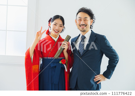 A man taking a photo of a woman in a hakama A man taking a photo of a woman in a hakama 111776422