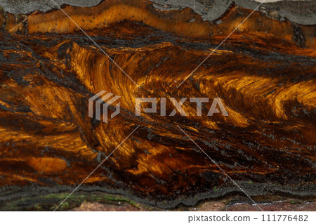 Macro stone tiger eye mineral in rock on black background Macro stone tiger eye mineral in rock on black background 111776482