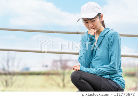 A young Asian woman who coughs and sits due to asthma and poor physical condition while exercising (painful and nausea) 111776678