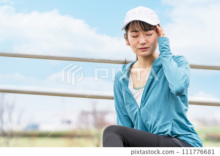 穿著運動服的亞洲女性在跑步/走路時患有頭痛/偏頭痛 111776681