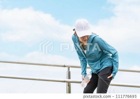 An Asian woman feels pain in her thighs and hamstrings while running or walking. 111776693