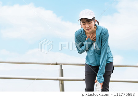 Asian woman in sportswear suffering from dyspnea, asthma, shortness of breath during exercise Asian woman in sportswear suffering from dyspnea, asthma, shortness of breath during exercise 111776698