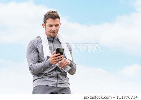 Caucasian man in sportswear using smartphone during exercise/training Caucasian man in sportswear using smartphone during exercise/training 111776714