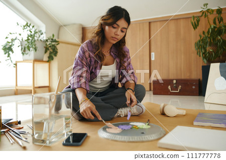 Creative teen girl mixing paints on palette Creative teen girl mixing paints on palette 111777778