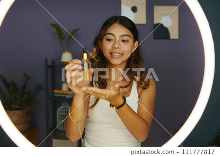 Girl filming moisturizing serum review for her blog 111777817
