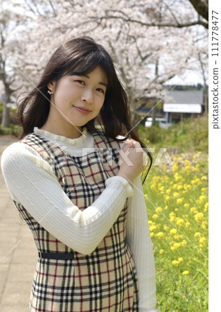 A young slim woman posing in a cherry blossom park A young slim woman posing in a cherry blossom park 111778477