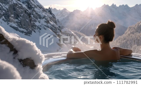 Woman relaxing in hot bath outdoors, sitting back and enjoying beautiful view on snowy mountains. Winter holidays in the mountains, hot water treatments concept 111782991