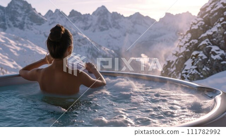 Woman relaxing in hot bath outdoors, sitting back and enjoying beautiful view on snowy mountains. Winter holidays in the mountains, hot water treatments concept Woman relaxing in hot bath outdoors, sitting back and enjoying beautiful view on snowy mountains. Winter holidays in the mountains, hot water treatments concept 111782992