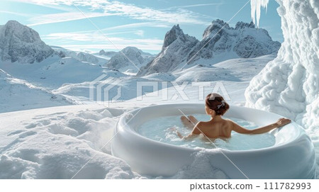 Woman relaxing in hot bath outdoors, sitting back and enjoying beautiful view on snowy mountains. Winter holidays in the mountains, hot water treatments concept 111782993