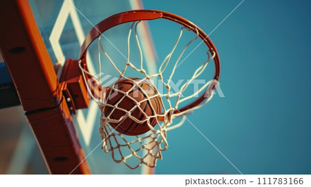 Basketball ball entered in the basket touching the net. Playing in the street on outdoor court, close up 111783166