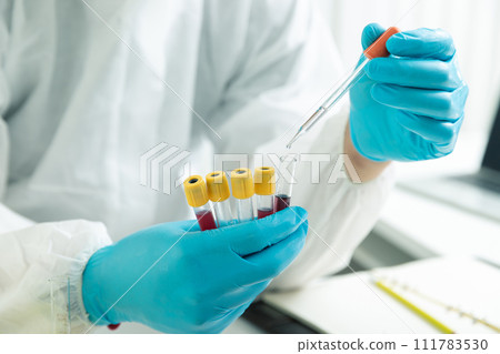 Researcher or scientists loads liquid sample into test tube in laboratory. Researchers are developing vaccines and medicine to treat the COVID-19 virus. Researcher or scientists loads liquid sample into test tube in laboratory. Researchers are developing vaccines and medicine to treat the COVID-19 virus. 111783530