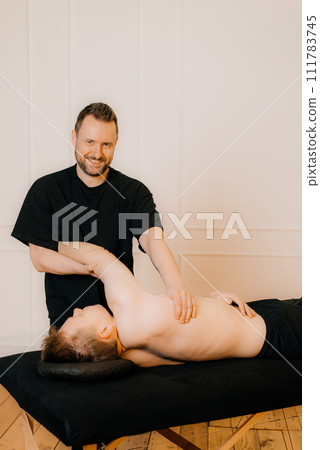 Relieving back muscle tension. Professional masseur massaging young man's back using Tapotement or chopping, tapping or hacking technique during Swedish massage therapy in spa salon or wellness center Relieving back muscle tension. Professional masseur massaging young man's back using Tapotement or chopping, tapping or hacking technique during Swedish massage therapy in spa salon or wellness center 111783745