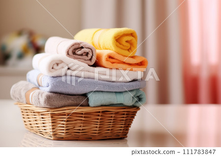 Clean towels inside a wicker laundry basket. Bath towels of different colors. 111783847