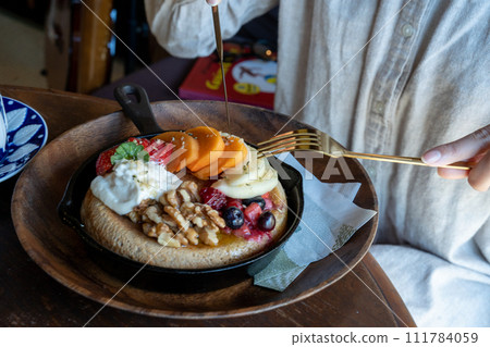 Woman eating pancake Woman eating pancake 111784059