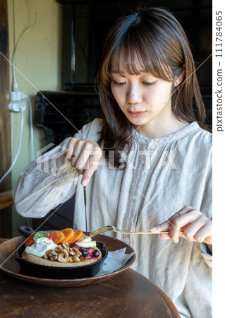 Woman eating pancake Woman eating pancake 111784065