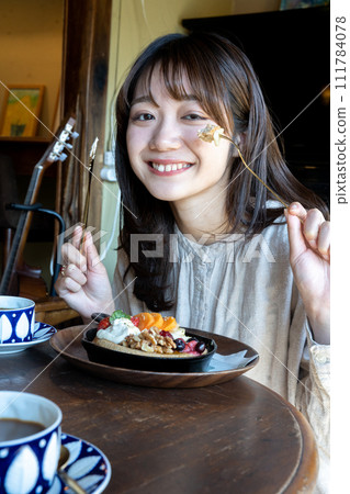 Woman eating pancake 111784078