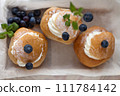 Top View of three Semla Cakes on wooden box with berries. semla top view from above 111784142