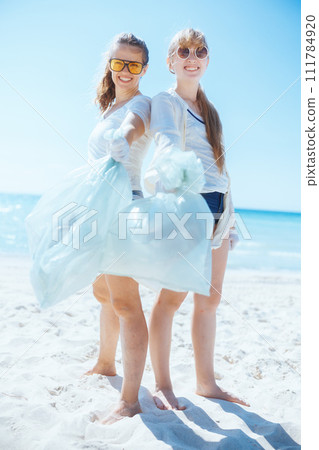 happy environment activists on beach collecting trash 111784920