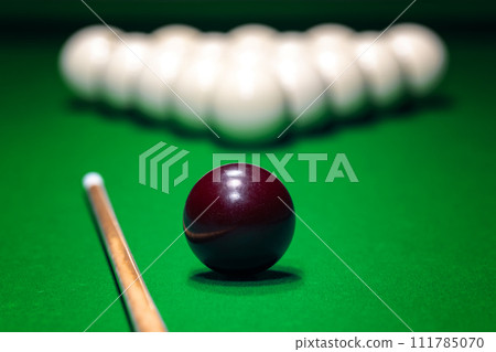 Ball is displayed on the pool table against the background of other balls and cue Ball is displayed on the pool table against the background of other balls and cue 111785070