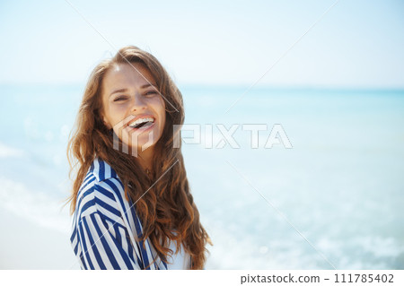 happy elegant woman on ocean shore having fun time 111785402