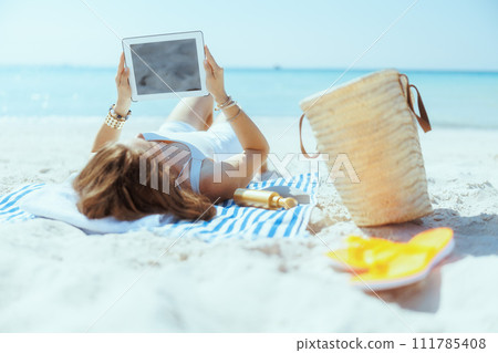 relaxed elegant woman on seacoast digital tablet blank screen 111785408