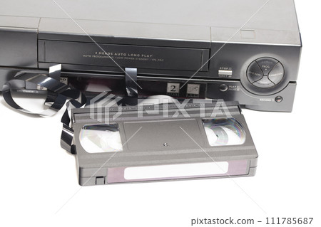 Retro video cassette recorder with VHS cassette with unwound tape isolated on white background. Retro video cassette recorder with VHS cassette with unwound tape isolated on white background. 111785687