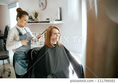 woman hairdresser in modern hair studio cutting hair 111786082