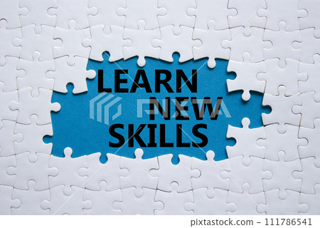 Learn new skills symbol. Concept words Learn new skills on white puzzle. Beautiful blue background. Business and Learn new skills concept. Copy space. 111786541