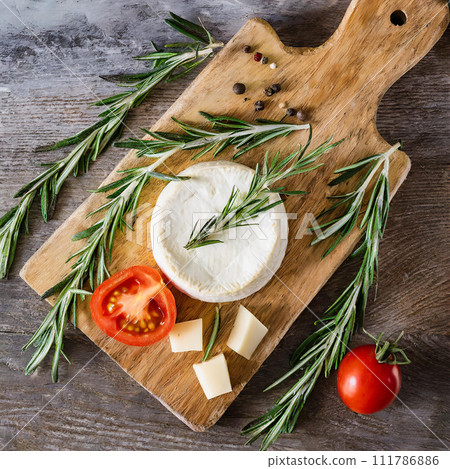 Flat lay of a healthy homemade cheese laying on the wooden board with tomatoes, gluten free 111786886