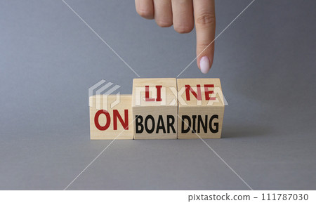 Online Onboarding symbol. Businessman Hand points at turned wooden cubes with words Online Onboarding. Beautiful grey background. Business and Online Onboarding concept. Copy space 111787030