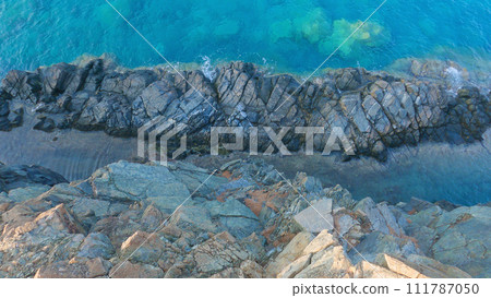 The rocky coastline of the Mediterranean Sea. View from above of the cliffs and blue water. Beautiful views from the famous Lycian Trail near the village. 111787050