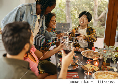 Happy friends enjoying in conversation and drinking wine during festive dinner at home party 111787400