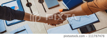 Close up of two business people shaking hands at office meeting. Partnership concept Close up of two business people shaking hands at office meeting. Partnership concept 111787478