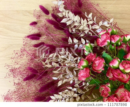 木質背景上的金色、紅色、粉紅色和紫色插花 111787898