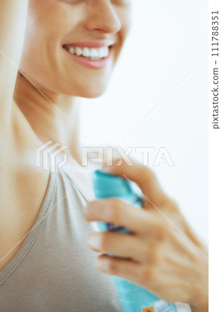 Closeup on young woman applying deodorant on underarm 111788351
