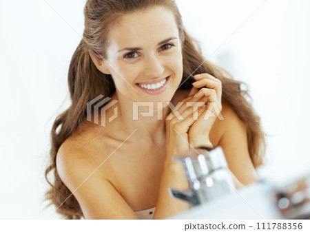 smiling young woman in bathroom smiling young woman in bathroom 111788356