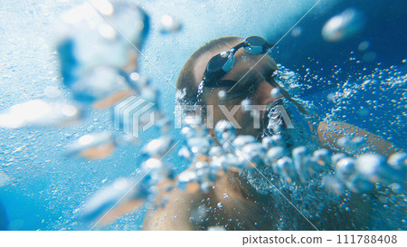 Snorkelling in the sea. A man with goggles on his head in the water among many bubbles. He has just jumped into the sea. The concept of summer travelling. Snorkelling in the sea. A man with goggles on his head in the water among many bubbles. He has just jumped into the sea. The concept of summer travelling. 111788408