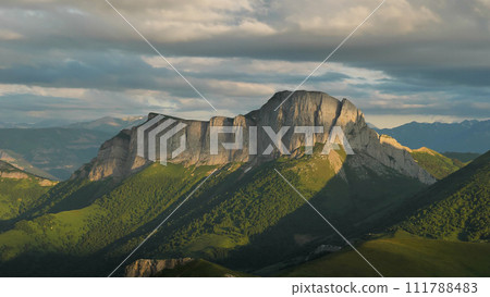 Powerful majestic rocks. Rain clouds looming over the mountains. Beautiful evening light. Mount Chertovoye Vorota or Acheshbok. Powerful majestic rocks. Rain clouds looming over the mountains. Beautiful evening light. Mount Chertovoye Vorota or Acheshbok. 111788483