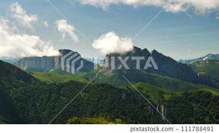 High majestic cliffs in the clouds. Two cliffs with a long steep precipice. View from the air. Mountains Chertovy Vorota. Travelling to wild, beautiful places of the planet. 111788491