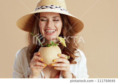 smiling 40 years old woman in blouse and shorts against beige 111788648