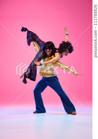 To rhythm of dance. Talented couple, dance partners in dynamic disco pose against gradient pink studio background. 111788826