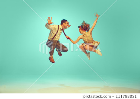 Portrait of modern jazz-dancers in mid-air against gradient mint background. Joyful dance partners performing dance. Vintage fashion. 111788851