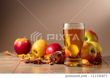 Apple juice with apples, cinnamon, and anise on a beige background. Apple juice with apples, cinnamon, and anise on a beige background. 111788871