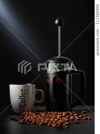 French press coffee and a cup on a black table. 111788900