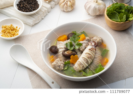 Stuffed squid soup,Clear Soup with Squid Stuffed with Minced Pork and dried shiitake mushroom in white bowl Stuffed squid soup,Clear Soup with Squid Stuffed with Minced Pork and dried shiitake mushroom in white bowl 111789077