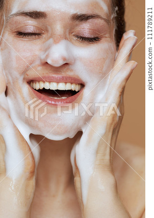 smiling young female with foaming face wash washing face smiling young female with foaming face wash washing face 111789211